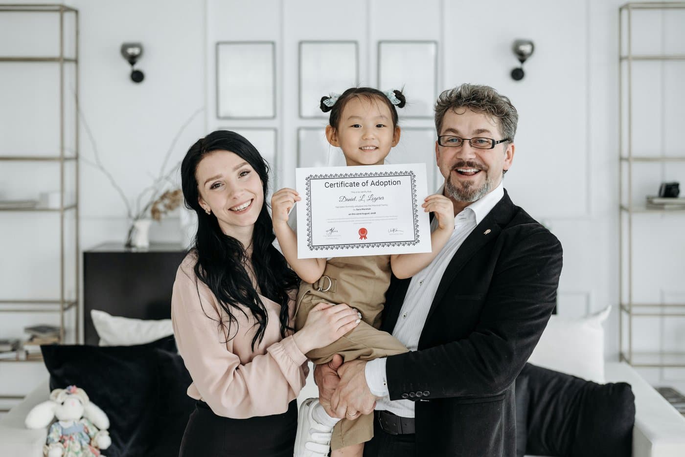 Asian girl holding adoption cert